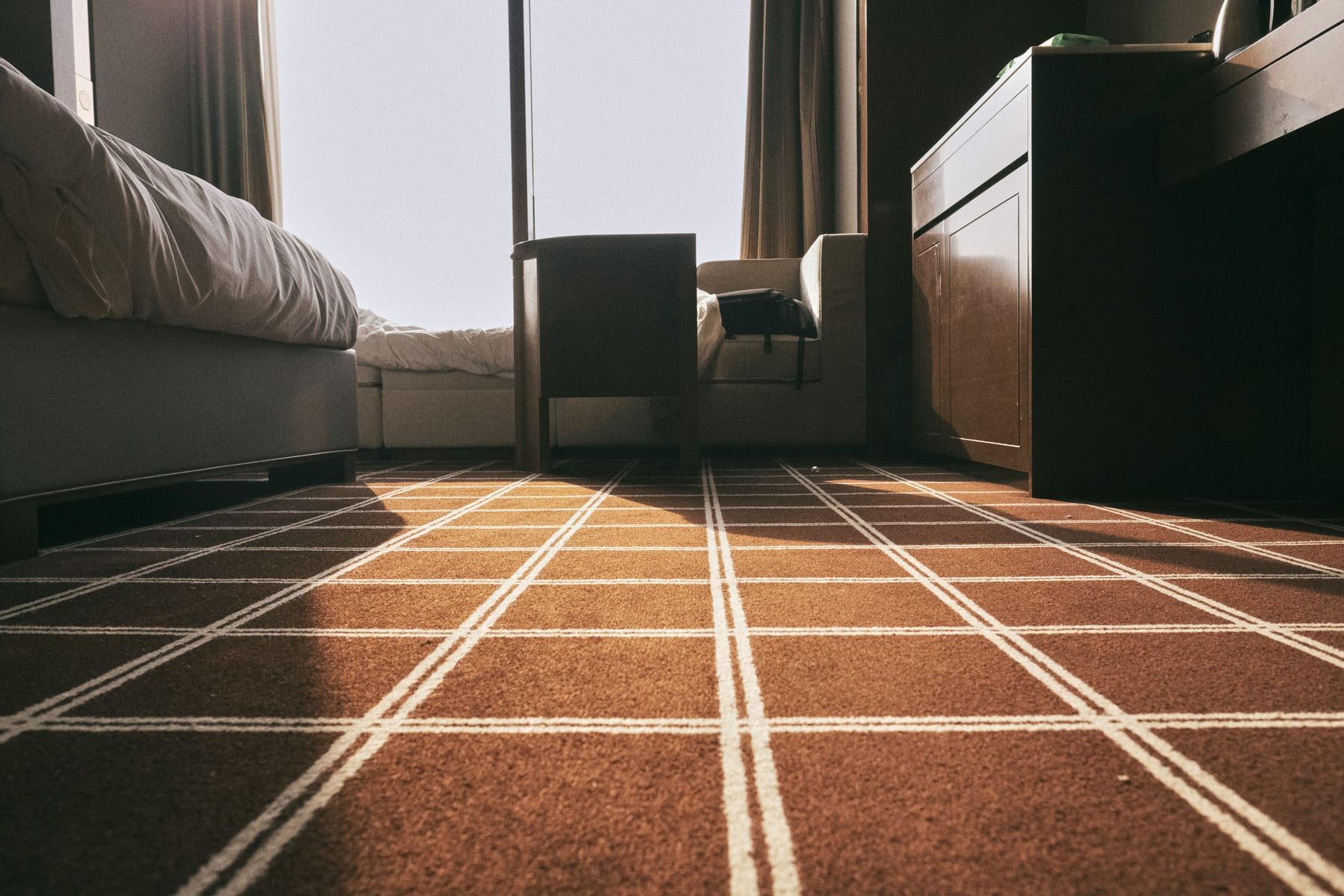 Technician deep-cleaning a living-room carpet with a professional stainless-steel wand in a Capitola home